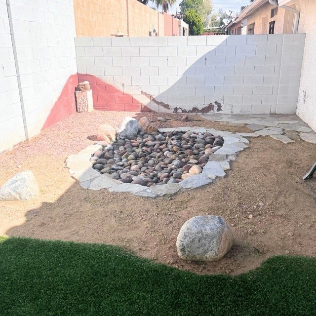 Landscaped backyard with rock garden and artificial turf